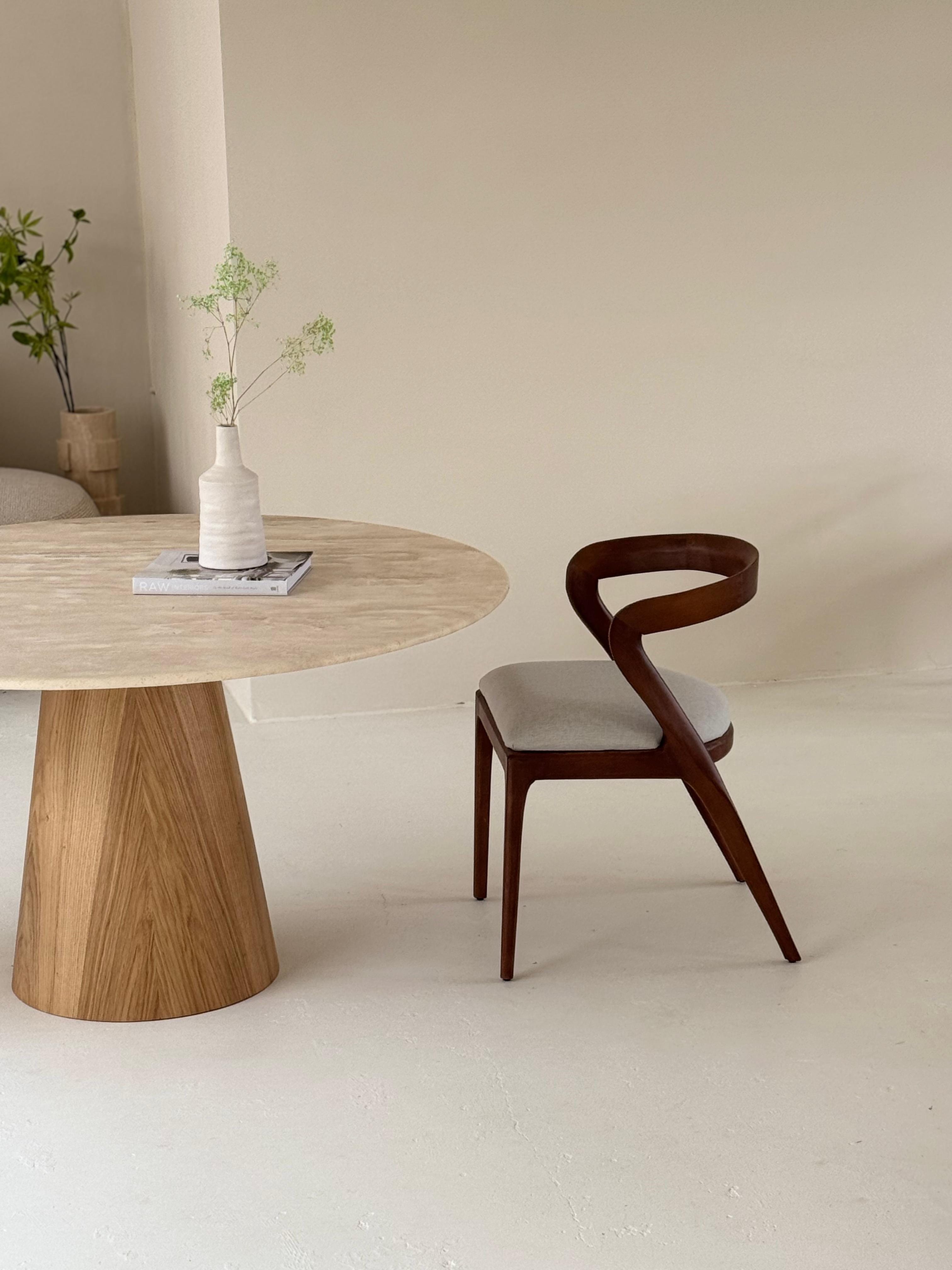 Oleandro | Travertine Dining Table with handcrafted wooden base and veincut stone top in a modern setting