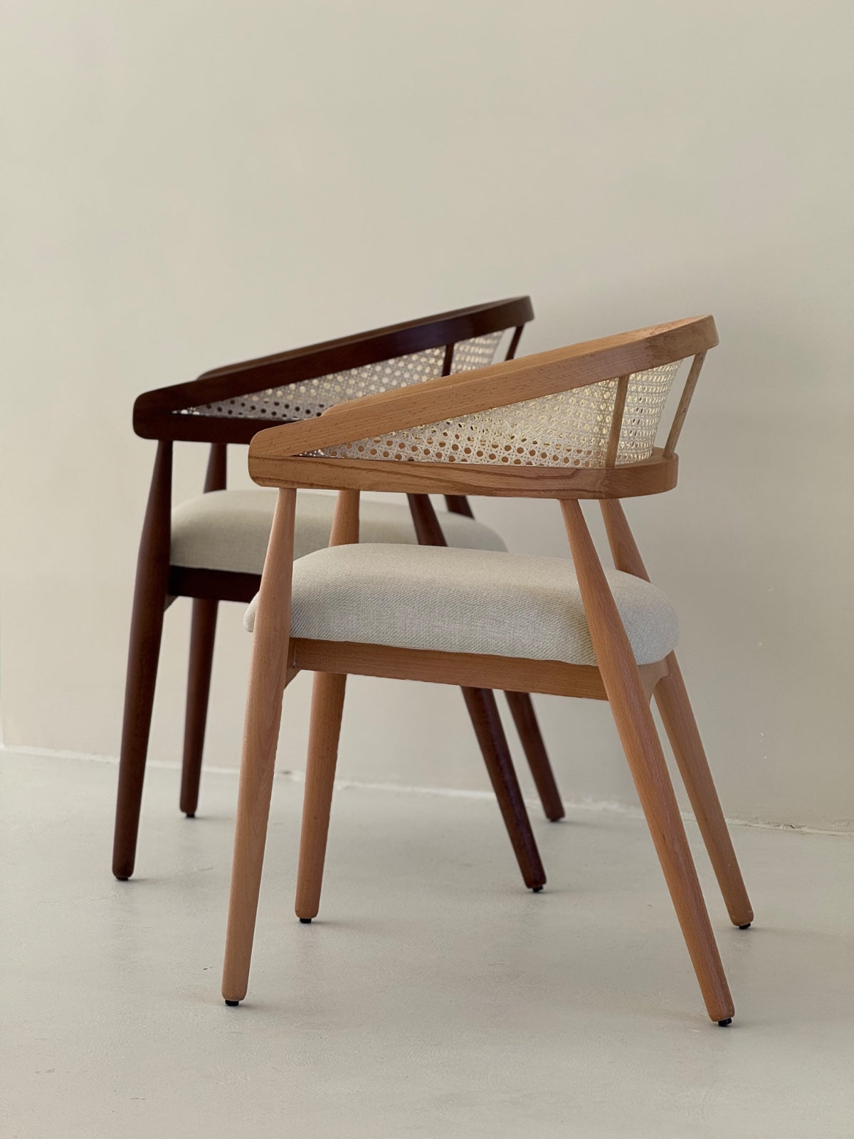 Side view of Gaia Dining Chair showing curved armrests and elegant wood grain