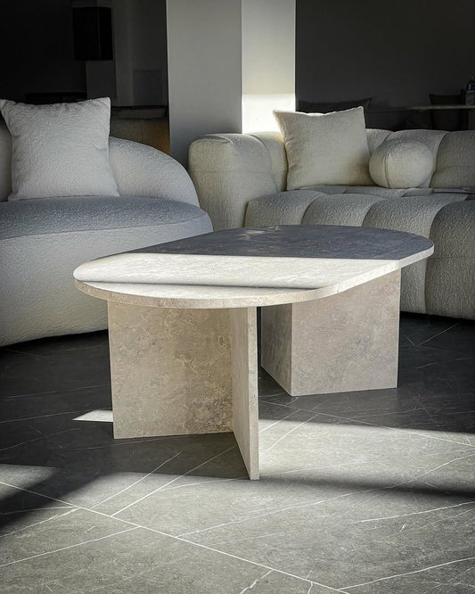 Twin Fold Travertine Coffee Table with twin-panel base and crosscut stone surface in a modern living room