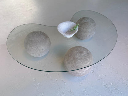 World Globe Organic-shaped Coffee Table with glass top and sculptural travertine base in a modern interior