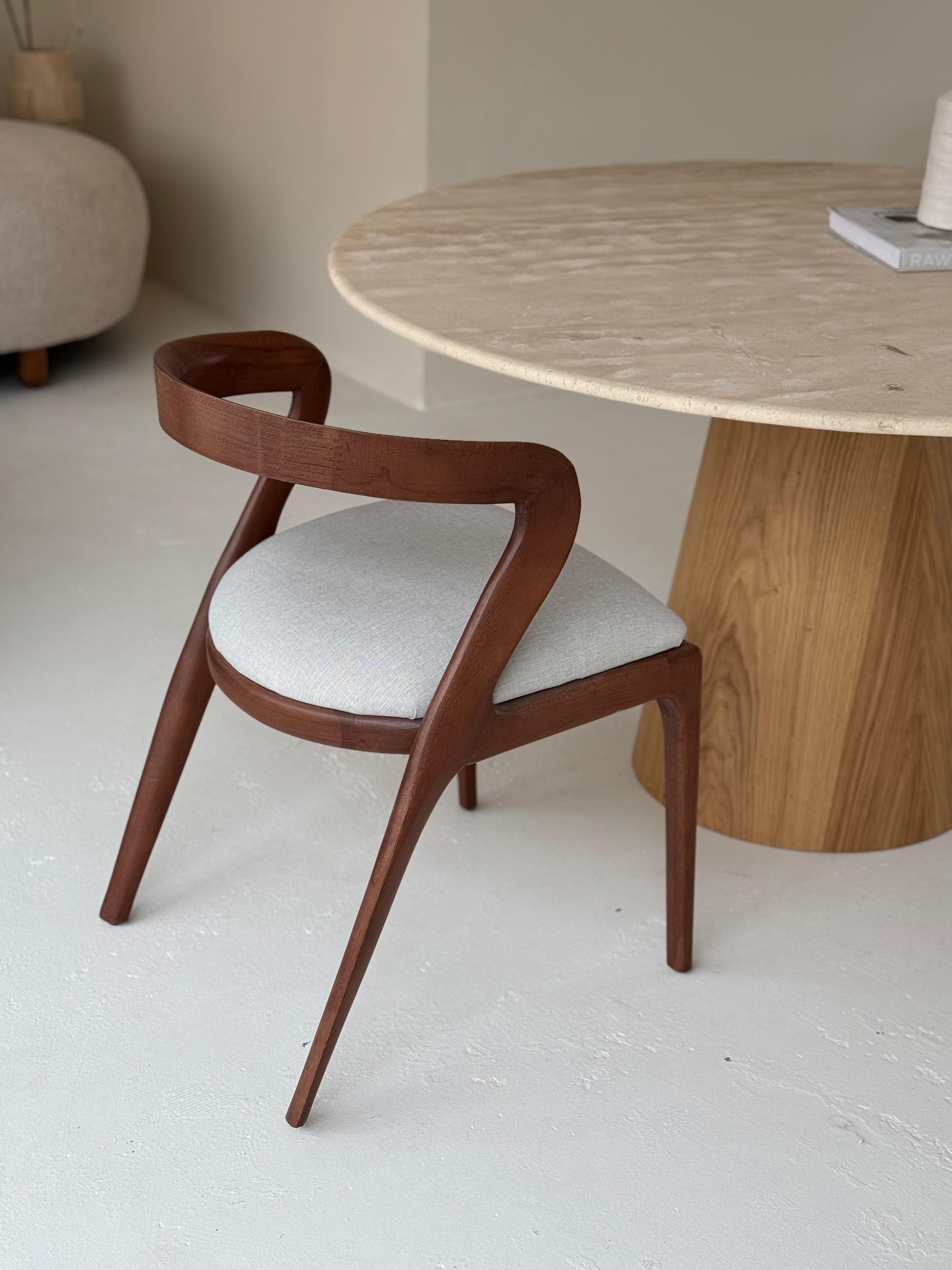 Oleandro | Travertine Dining Table with handcrafted wooden base and veincut stone top in a modern setting