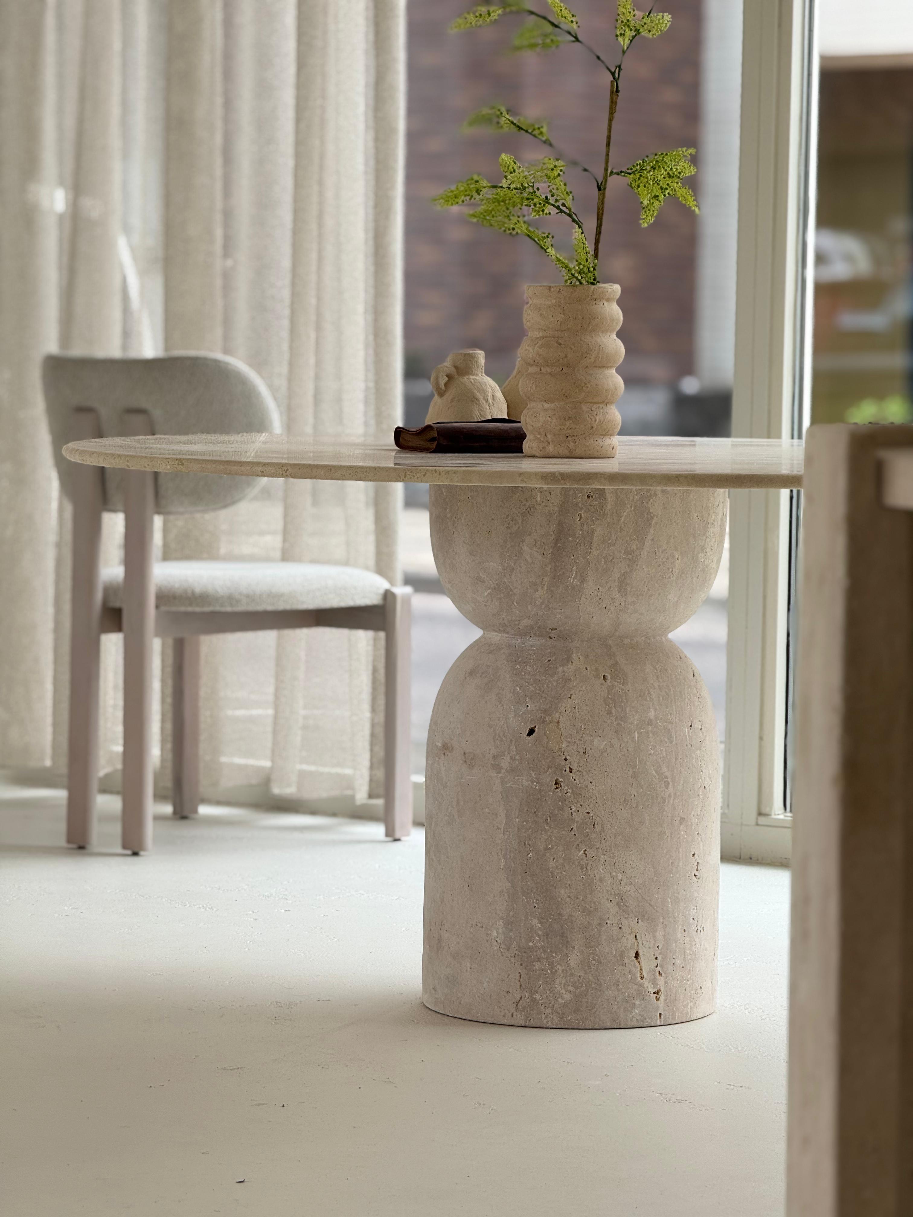 Oreo | Travertine Twist Table with sculptural twisted base and honed round top, styled in a minimalist dining interior