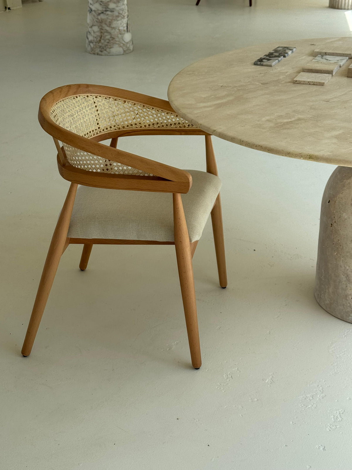 Gaia Dining Chair with walnut-stained frame and woven cane backrest in light brown setting