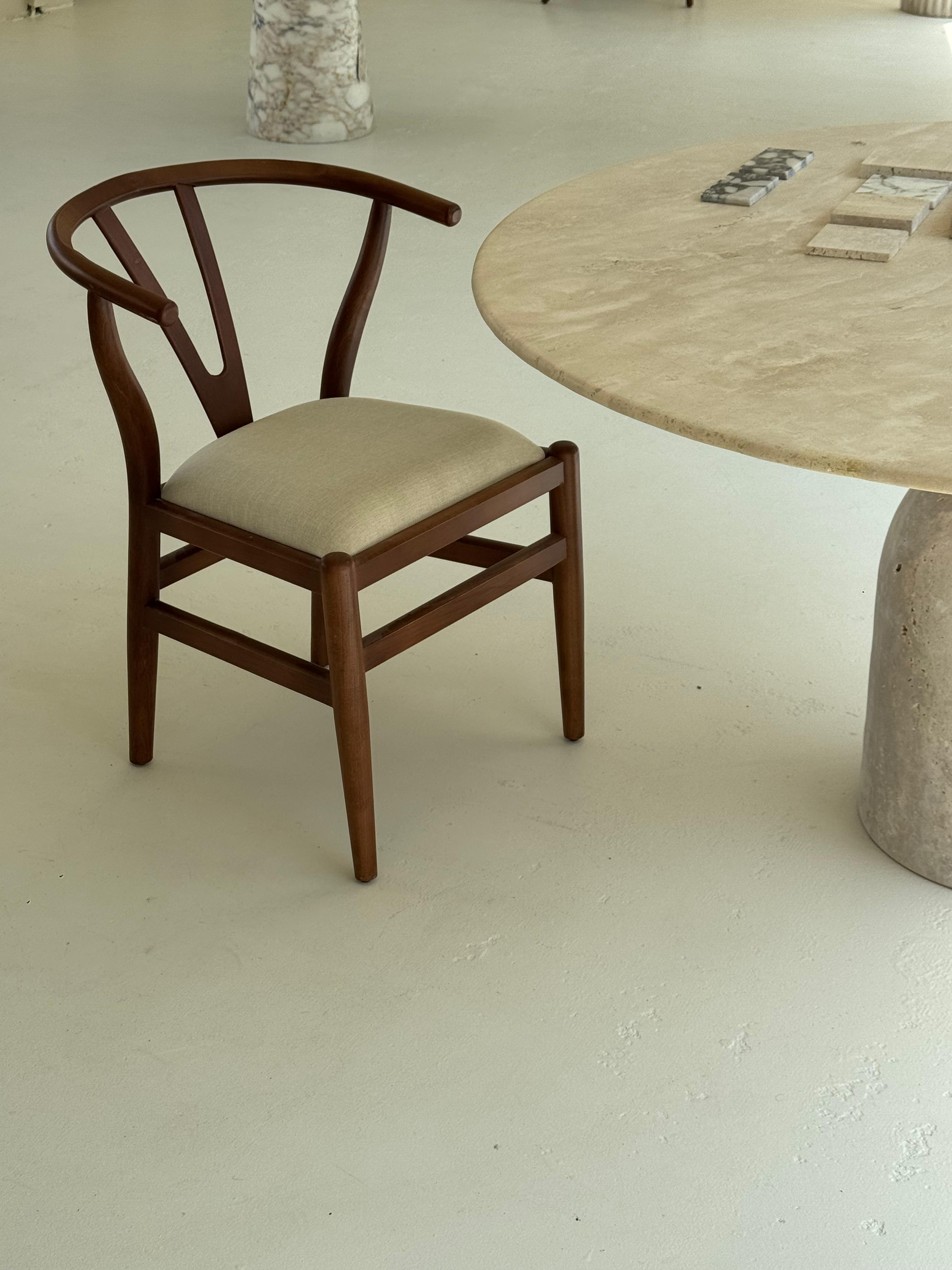 Modern dining chair in warm wood with curved backrest and neutral fabric cushion