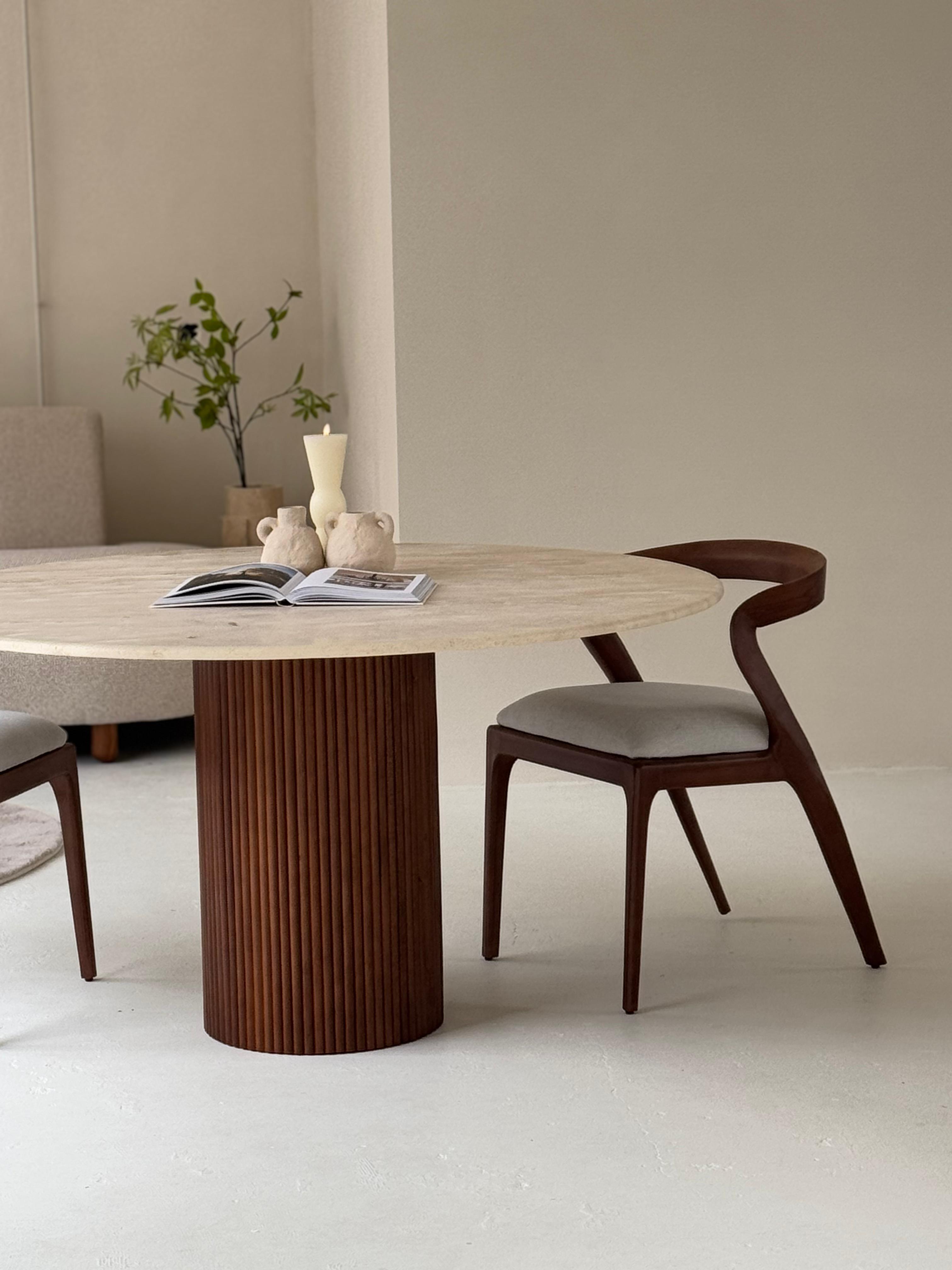 Lavanda dining table featuring veincut travertine top and handcrafted pedestal