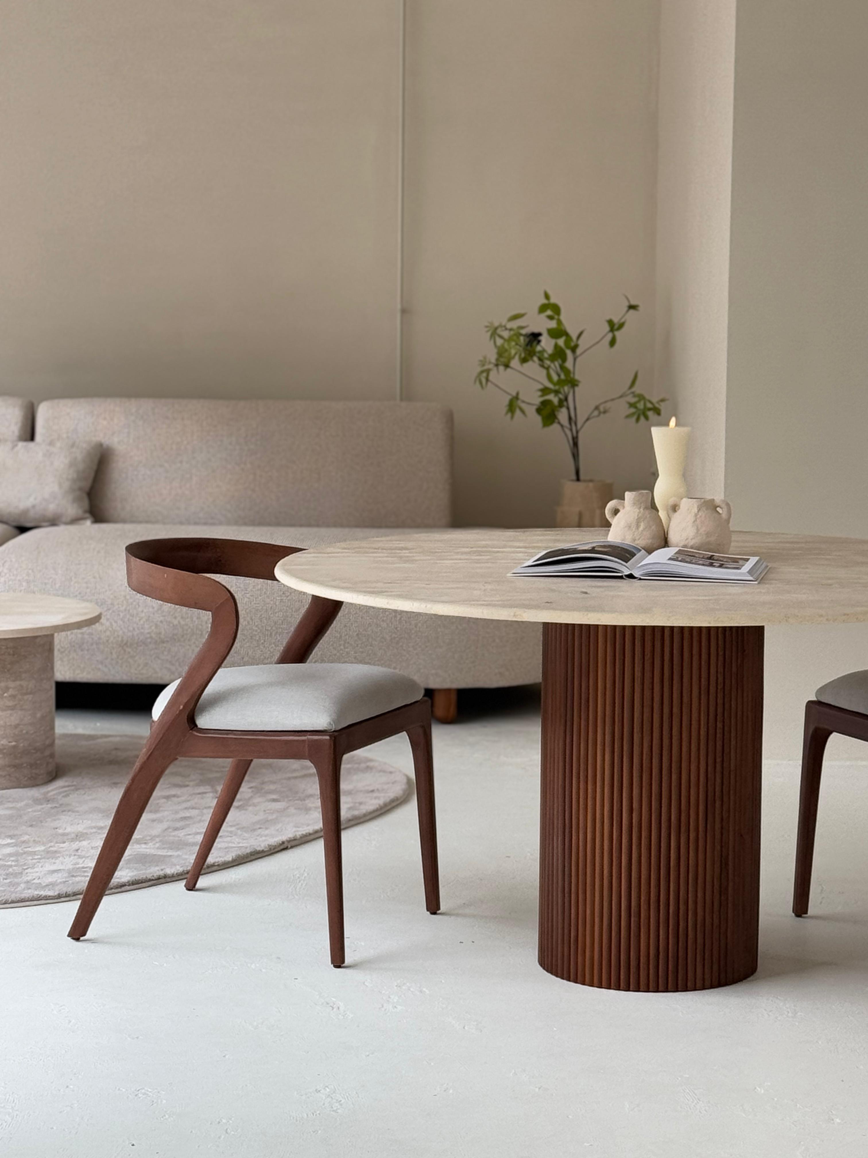 Lavanda dining table featuring veincut travertine top and handcrafted pedestal